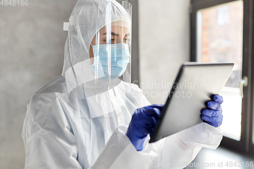 Image of doctor in protective wear with tablet computer