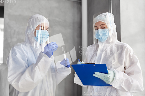 Image of doctors in medical mask and shield with clipboard