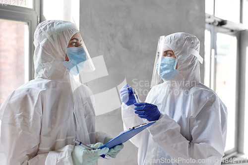 Image of doctors in medical mask and shield with clipboard