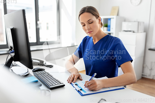 Image of doctor or nurse with clipboard working at hospital