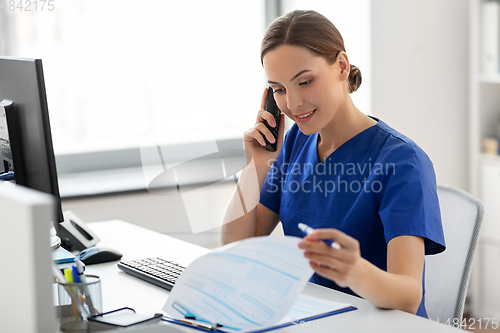 Image of doctor with computer calling on phone at hospital