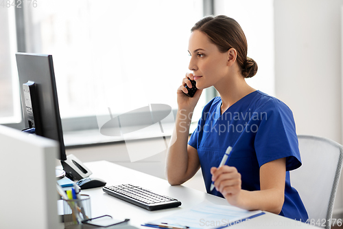 Image of doctor with computer calling on phone at hospital