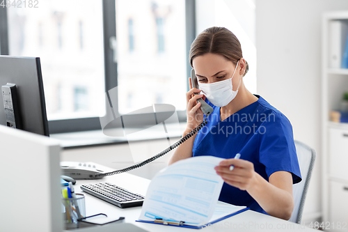 Image of doctor with computer calling on phone at hospital