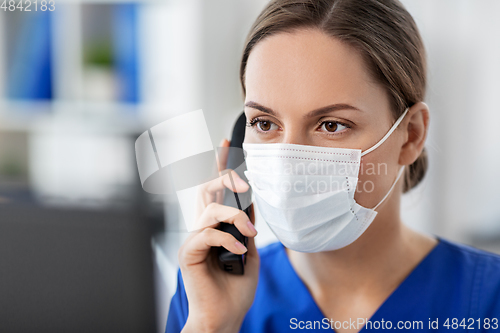 Image of doctor with computer calling on phone at hospital