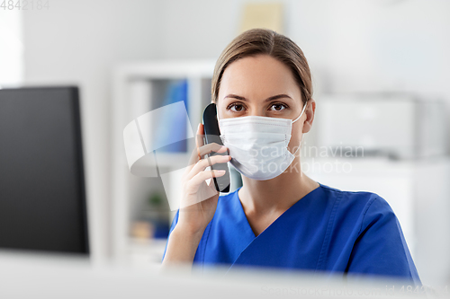 Image of doctor with computer calling on phone at hospital