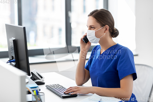 Image of doctor with computer calling on phone at hospital