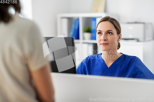 Image of doctor with computer and patient at hospital