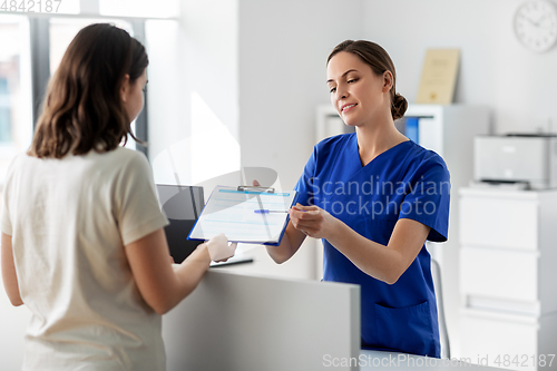 Image of doctor with clipboard and patient at hospital