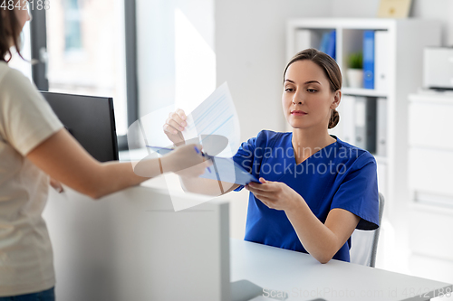 Image of doctor with clipboard and patient at hospital
