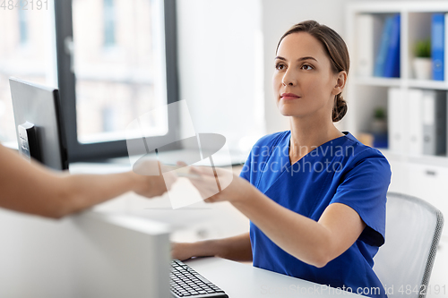 Image of doctor and patient with credit card at hospital