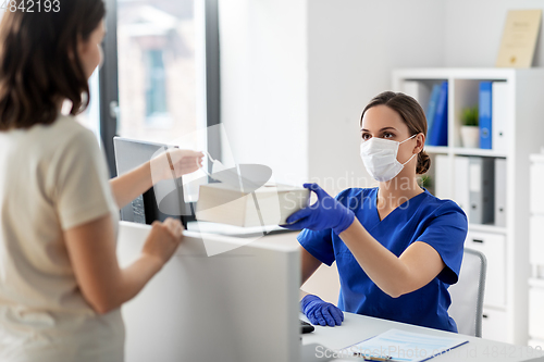 Image of doctor offering mask to patient at hospital