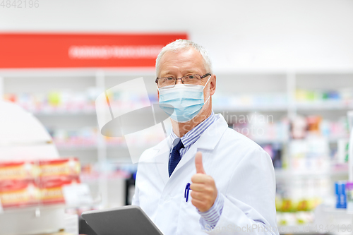 Image of old apothecary in mask with tablet pc at pharmacy