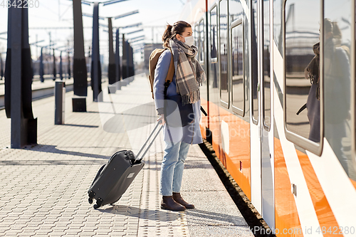 Image of woman in protective face mask at railway station