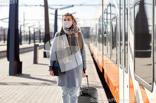 Image of woman in protective face mask at railway station