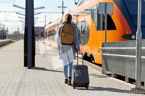 Image of woman with travel bag on railway station