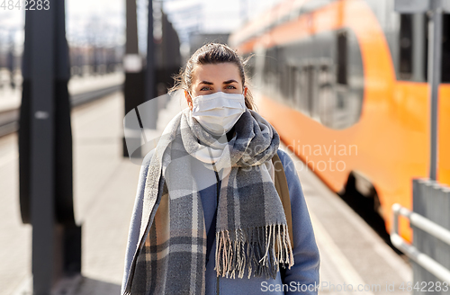 Image of woman in protective face mask at railway station
