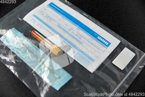 Image of beaker with test, cotton swab and medical report