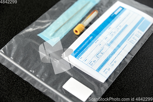 Image of beaker with test, cotton swab and medical report