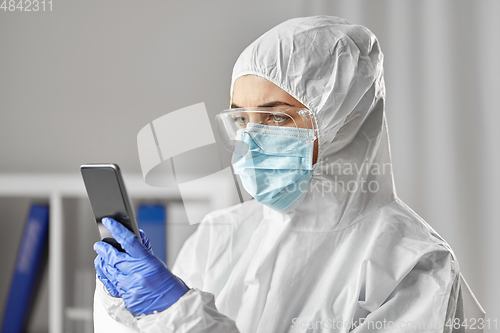 Image of doctor in protective wear with smartphone
