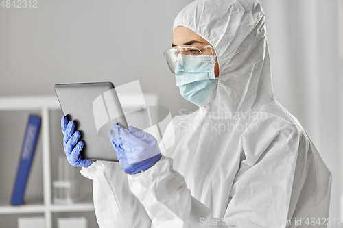 Image of doctor in protective wear with tablet computer