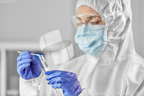 Image of scientist holding beaker with coronavirus test