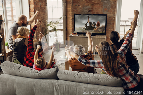 Image of Excited, happy big family team watch sport match together on the couch at home