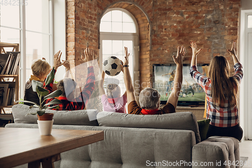 Image of Excited, happy big family team watch sport match together on the couch at home