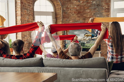 Image of Excited, happy big family team watch sport match together on the couch at home