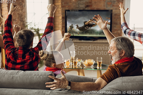 Image of Excited, happy big family team watch sport match together on the couch at home