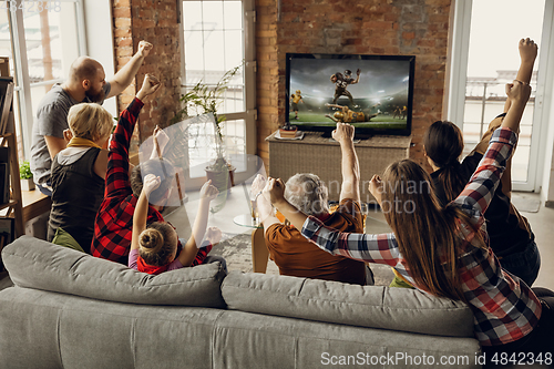 Image of Excited, happy big family team watch sport match together on the couch at home