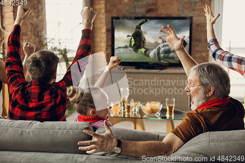 Image of Excited, happy big family team watch sport match together on the couch at home