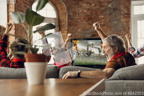Image of Excited, happy big family team watch sport match together on the couch at home