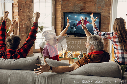 Image of Excited, happy big family team watch sport match together on the couch at home