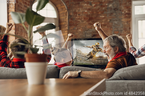 Image of Excited, happy big family team watch sport match together on the couch at home