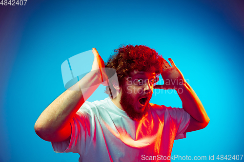 Image of Caucasian man\'s portrait isolated on blue studio background in neon light