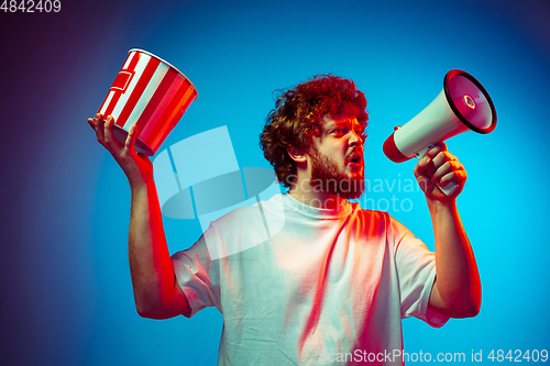 Image of Caucasian man\'s portrait isolated on blue studio background in neon light