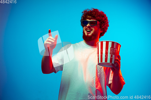 Image of Caucasian man\'s portrait isolated on blue studio background in neon light