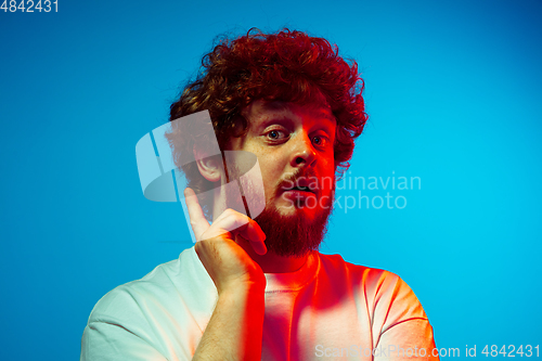 Image of Caucasian man\'s portrait isolated on blue studio background in neon light