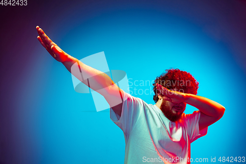 Image of Caucasian man\'s portrait isolated on blue studio background in neon light