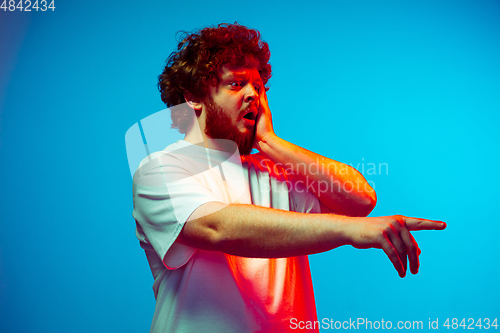 Image of Caucasian man\'s portrait isolated on blue studio background in neon light