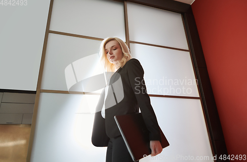 Image of Young adult business woman wearing formalwear and carrying the l