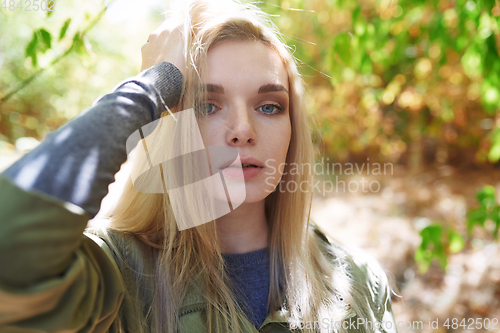 Image of Young adult woman spending quality time in the forest