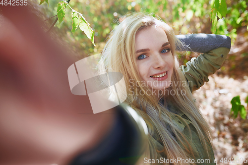 Image of Young adult woman spending quality time in the forest