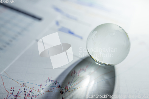 Image of Glass globe on stock market chart