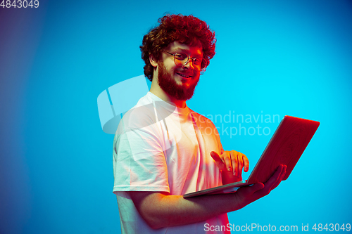 Image of Caucasian man\'s portrait isolated on blue studio background in neon light