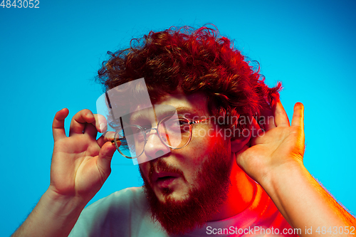 Image of Caucasian man\'s portrait isolated on blue studio background in neon light