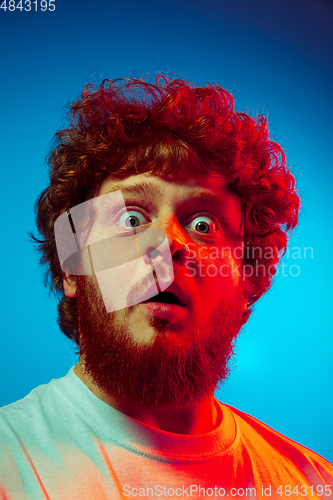 Image of Caucasian close up man\'s portrait isolated on blue studio background in neon light