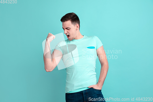 Image of Caucasian young man\'s portrait on blue studio background