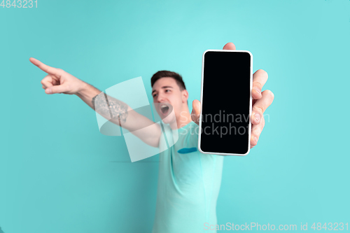 Image of Caucasian young man\'s portrait on blue studio background