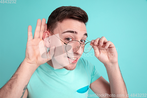 Image of Caucasian young man\'s portrait on blue studio background